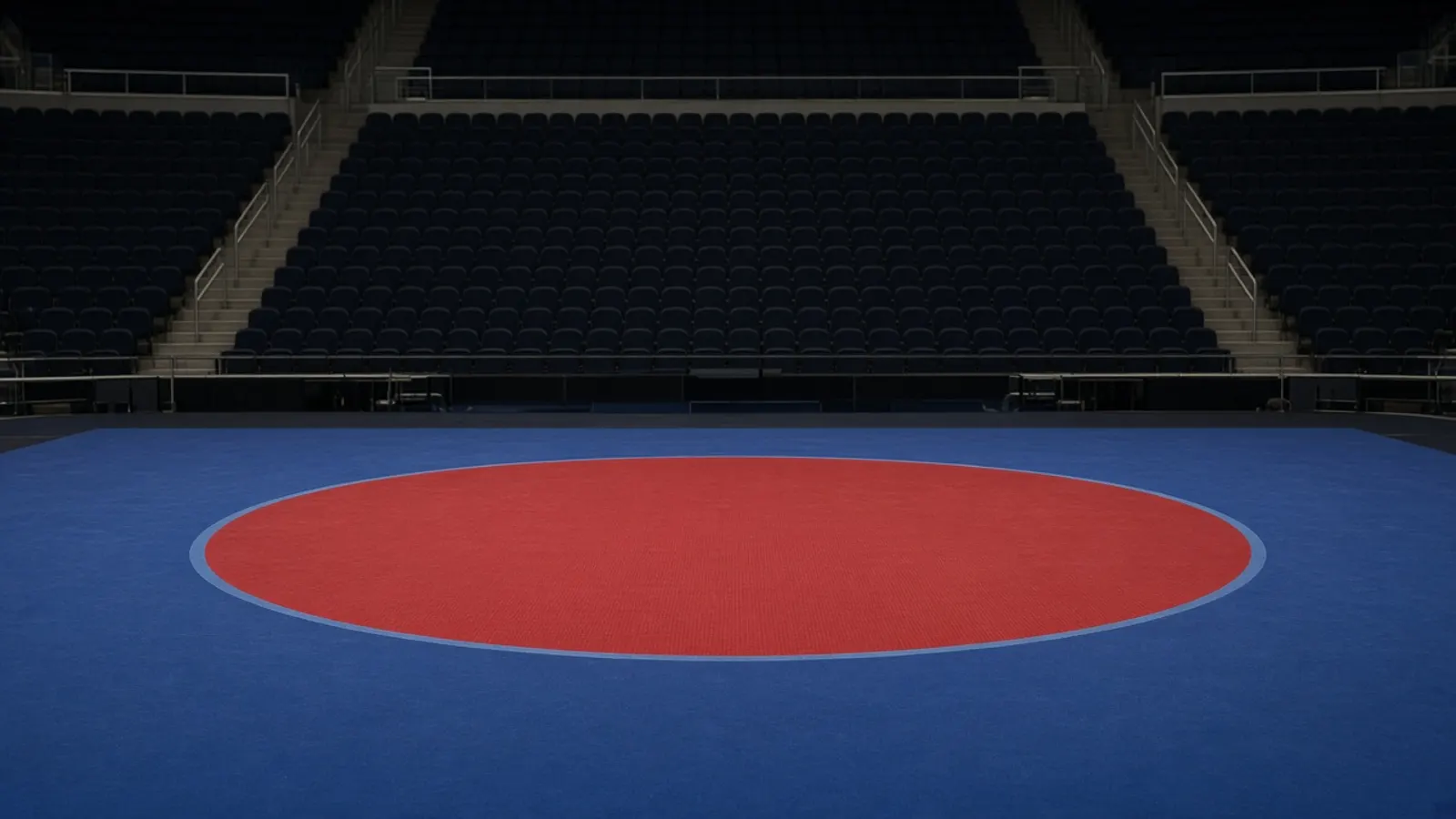 An empty arena, blue mat and dark seats, before a session.