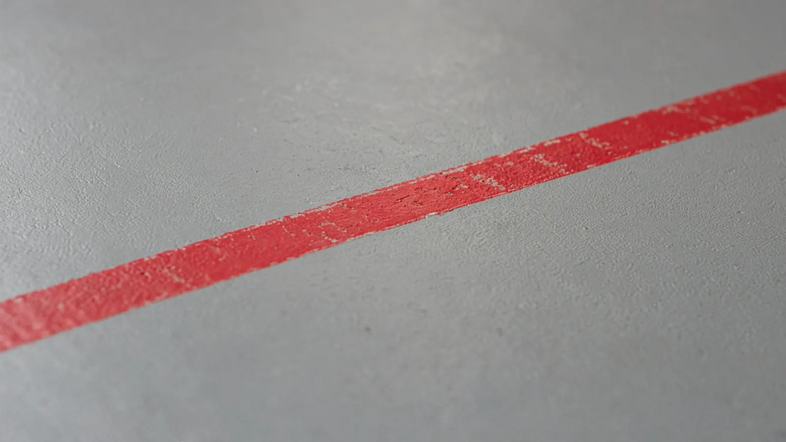 A scuffed red boundary line on a wrestling mat.